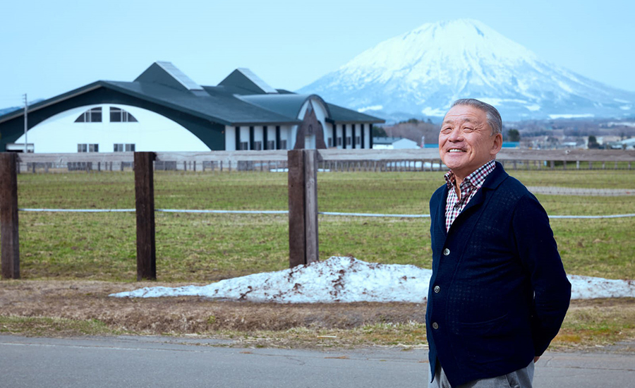 “蝦夷富士“と呼ばれ親しまれる羊蹄山を背にレイクヴィラファーム代表・岩崎伸道氏