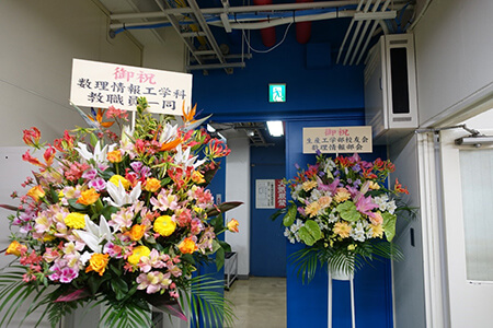 スタジオの入り口には教職員、生産工学部校友会からの祝花