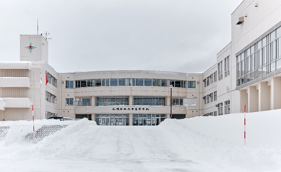 札幌日大高の校舎正門を臨む。冬の日らしく雪が周囲に積もっている