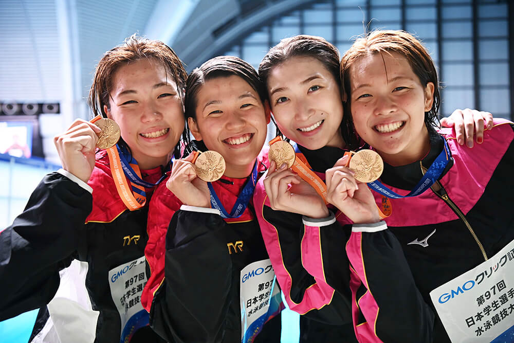 優勝メダルを手に笑顔全開の400mリレーメンバー。左から山本選手、小堀選手、池江選手、持田選手。