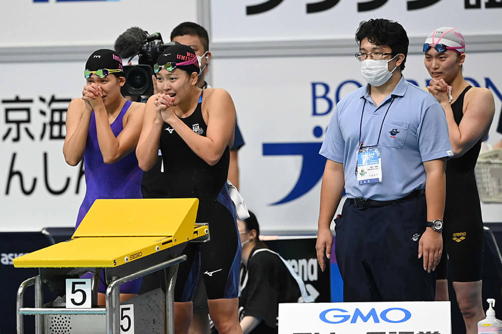 泳ぎ終えた選手たちが手を合わせて池江選手の力泳を見守る。