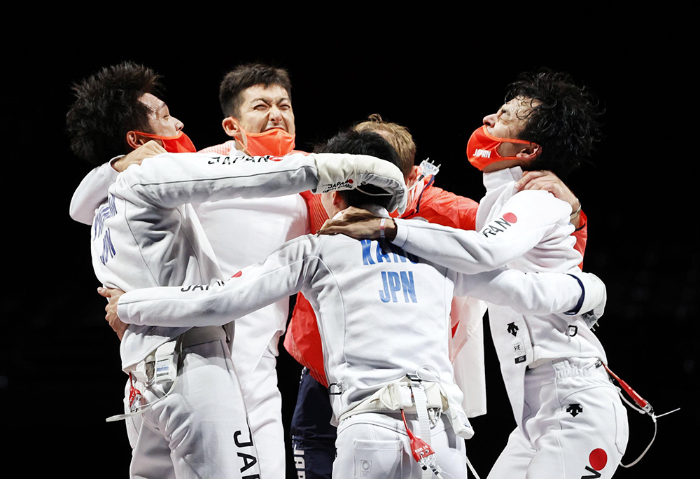 ROCに45-36で勝利し、山田選手（左端）と男子エペ団体メンバー、コーチが肩を組んで喜び合う。