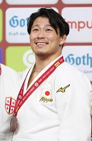 柔道ＧＳ 男子９０㎏級で３位になり、銅メダルを胸に笑顔の向翔一郎選手（共同通信社）